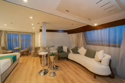 a bedroom with a bed and a couch and a table at فندق نايل ستوري سوهاج in Suwhaj