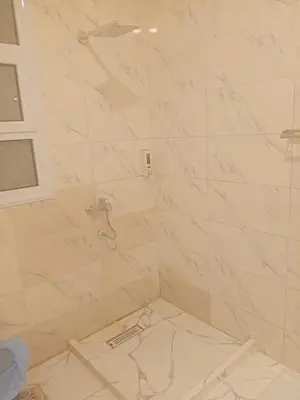 a bathroom with a shower with marble tiles at Habu Palace home in Luxor