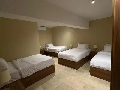 a hotel room with two beds with white sheets at The Fit Stop Hostel in Hurghada