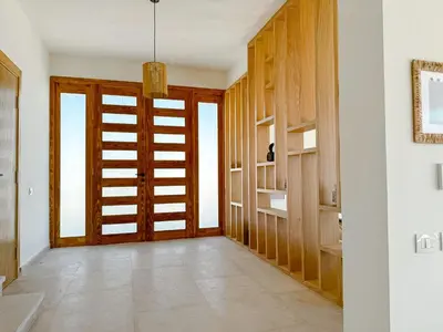 a hallway with a wooden door and shelves at Amazing 4 BR Villa in Soma Bay Movin Stay in Hurghada