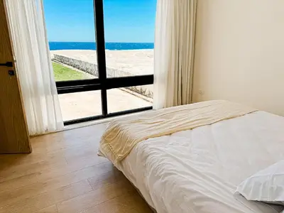 a bedroom with a bed and a view of the beach at Amazing 4 BR Villa in Soma Bay Movin Stay in Hurghada