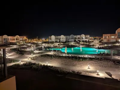 a view of a resort at night with lights at EL GOUNA Boho Beach Chalet with pool access in Hurghada