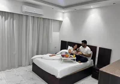 a man and a woman sitting on a bed at Fanadir Bay Beach Resort & Aqua Park in Hurghada