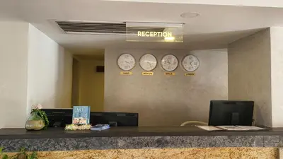 a reception desk with four clocks on the wall at Fanadir Bay Beach Resort & Aqua Park in Hurghada