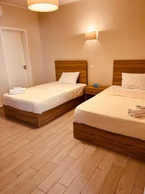 two beds in a room with wooden floors at 2BR Ground Floor Apartment with Heated Pool in Bali El Gouna in Hurghada