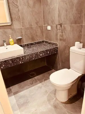 a bathroom with a white toilet and a sink at 2BR Ground Floor Apartment with Heated Pool in Bali El Gouna in Hurghada