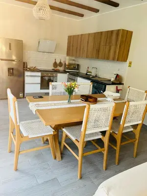 a dining room with a wooden table and chairs at 2BR Ground Floor Apartment with Heated Pool in Bali El Gouna in Hurghada
