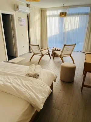 a bedroom with a bed and two chairs and a table at 2BR Ground Floor Apartment with Heated Pool in Bali El Gouna in Hurghada