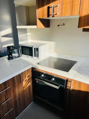 a kitchen with a microwave and a stove top oven at Cyan Lakefront 3BR Townhouse El Gouna in Hurghada