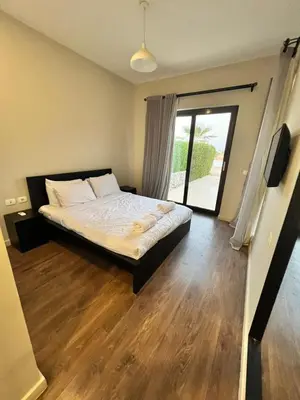 a bedroom with a bed and a large window at Cyan Lakefront 3BR Townhouse El Gouna in Hurghada