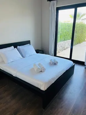 a bedroom with a bed with two towels on it at Cyan Lakefront 3BR Townhouse El Gouna in Hurghada