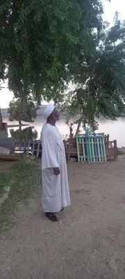 a man in a robe standing next to a beach at جيست هاوس جبل شيشه سيدون in Maḩaţţat ash Shallāl