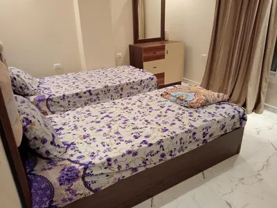 a bedroom with two beds and a dresser at Luxury Flat 3 rooms in Hurghada