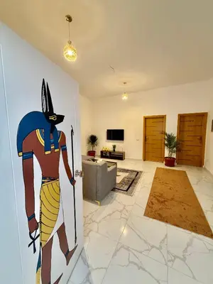 a room with a wall with a painting of a cat at Anubis Guesthouse in Luxor