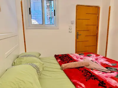 a bed in a small room with a window at Anubis Guesthouse in Luxor