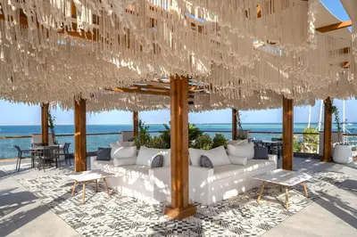a pavilion with white furniture and a view of the ocean at Rixos Premium Magawish Bay View in Hurghada