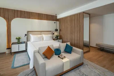 a bedroom with a large bed and a couch at Rixos Premium Magawish Bay View in Hurghada