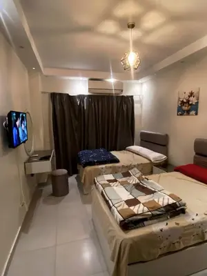 a room with three beds and a flat screen tv at florenza khamsin resort hurghada in Hurghada