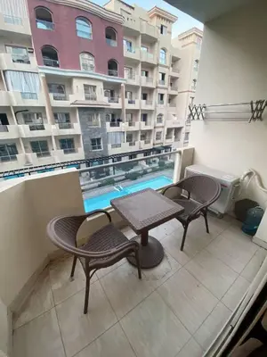 a balcony with a table and chairs and a swimming pool at florenza khamsin resort hurghada in Hurghada