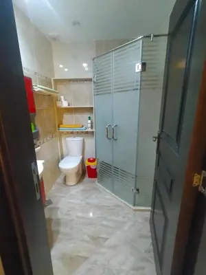 a bathroom with a toilet and a glass shower at Sea View Apartment Inside Gravity Hotel in Hasheesh Plain in Hurghada