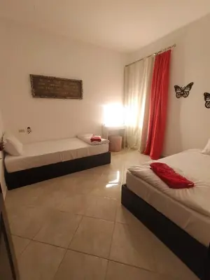 a bedroom with two beds and a butterfly on the wall at Sea View Apartment Inside Gravity Hotel in Hasheesh Plain in Hurghada