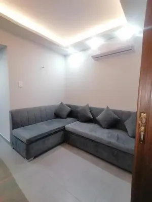 a living room with a gray couch in a room at Sea View Apartment Inside Gravity Hotel in Hasheesh Plain in Hurghada