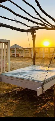 a bed is chained up on the beach with the sunset at Princess Resort Lovely Studio in Hurghada