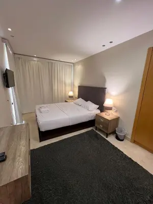 a bedroom with a bed and two lamps and a television at Ground Floor 1 Bedroom Scrub Unit in El Gouna in Hurghada
