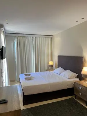 a bedroom with a large bed and a television at Ground Floor 1 Bedroom Scrub Unit in El Gouna in Hurghada