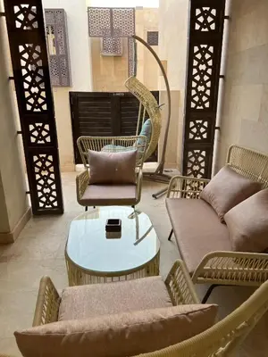a room with chairs and a table and a couch at Ground Floor 1 Bedroom Scrub Unit in El Gouna in Hurghada