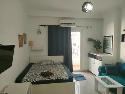 a small bedroom with a bed and a couch at Sherathon studio Pavel in Hurghada