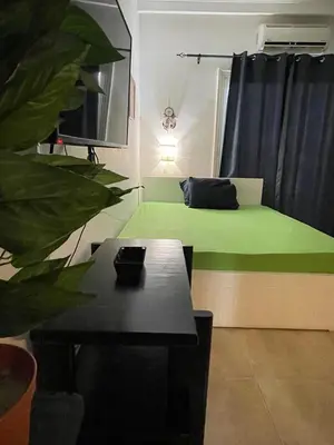 a room with a green bed and a table at Sherathon studio Pavel in Hurghada