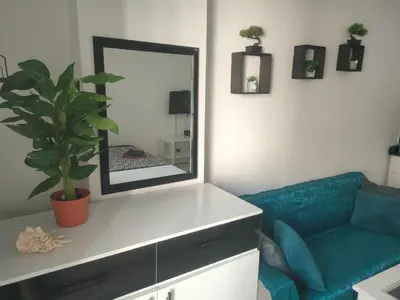 a living room with a mirror and a blue couch at Sherathon studio Pavel in Hurghada