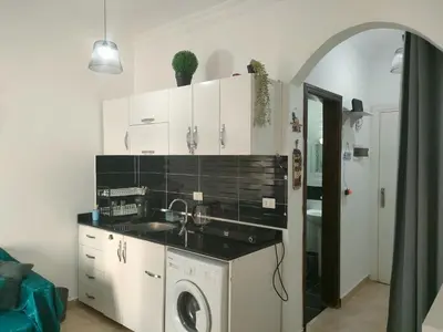 a kitchen with a sink and a washing machine at Sherathon studio Pavel in Hurghada