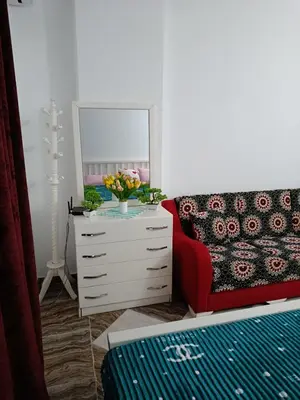 a living room with a dresser and a red couch at Sherathon studio Sheri in Hurghada