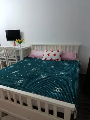 a bed with a green comforter and pink pillows at Sherathon studio Sheri in Hurghada
