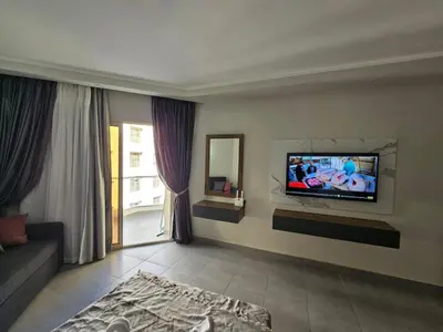 a living room with a flat screen tv on the wall at Scandic Resort Hurghada App-C310 in Hurghada