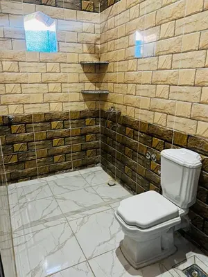 a bathroom with a toilet and a shower at Adam Guesthouse in Al Kawāmil Qiblī