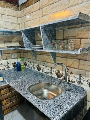 a kitchen with a sink and a stone wall at Adam Guesthouse in Al Kawāmil Qiblī