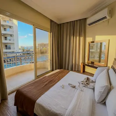 a bedroom with a large bed and a large window at La Quinta Beach Resort in Hurghada in Hurghada