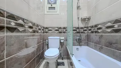 a bathroom with a toilet and a bath tub at La Quinta Beach Resort in Hurghada in Hurghada