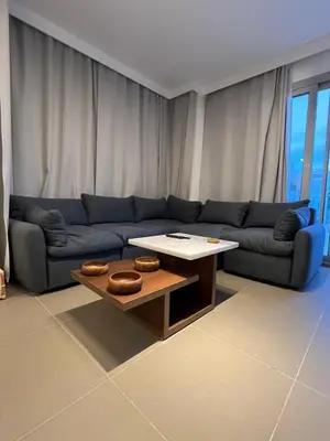a living room with a blue couch and a coffee table at Sholan El Gouna 2 Bedroom Apartment in Hurghada