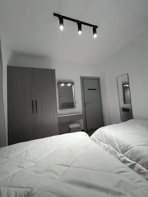 a bedroom with two white beds and a mirror at Sholan El Gouna 2 Bedroom Apartment in Hurghada