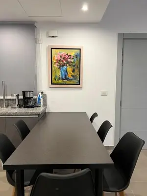 a black table in a kitchen with a painting on the wall at Sholan El Gouna 2 Bedroom Apartment in Hurghada