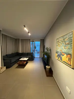 a living room with a couch and a painting on the wall at Sholan El Gouna 2 Bedroom Apartment in Hurghada