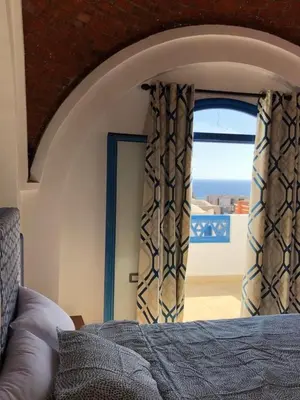 a bedroom with a window with a view of the ocean at Chalet with private pool in Hurghada