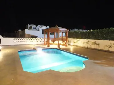 a swimming pool at night with a gazebo at Chalet with private pool in Hurghada