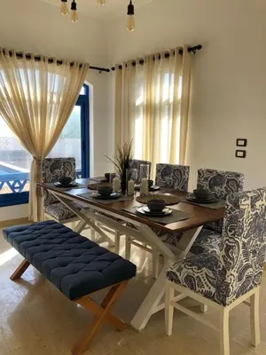 a dining room with a wooden table and chairs at Chalet with private pool in Hurghada