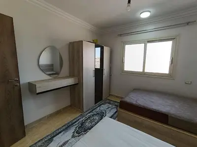 a bedroom with a bed and a mirror and a window at 3 Bedroom in Lotus in Naj‘ al Maḩaţţah