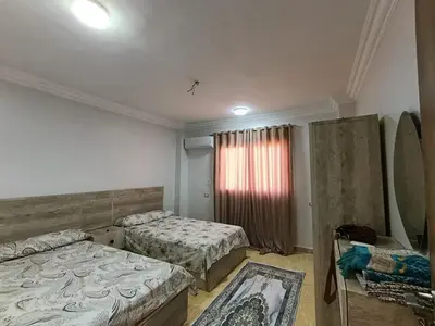 a room with two beds and a window in it at 3 Bedroom in Lotus in Naj‘ al Maḩaţţah